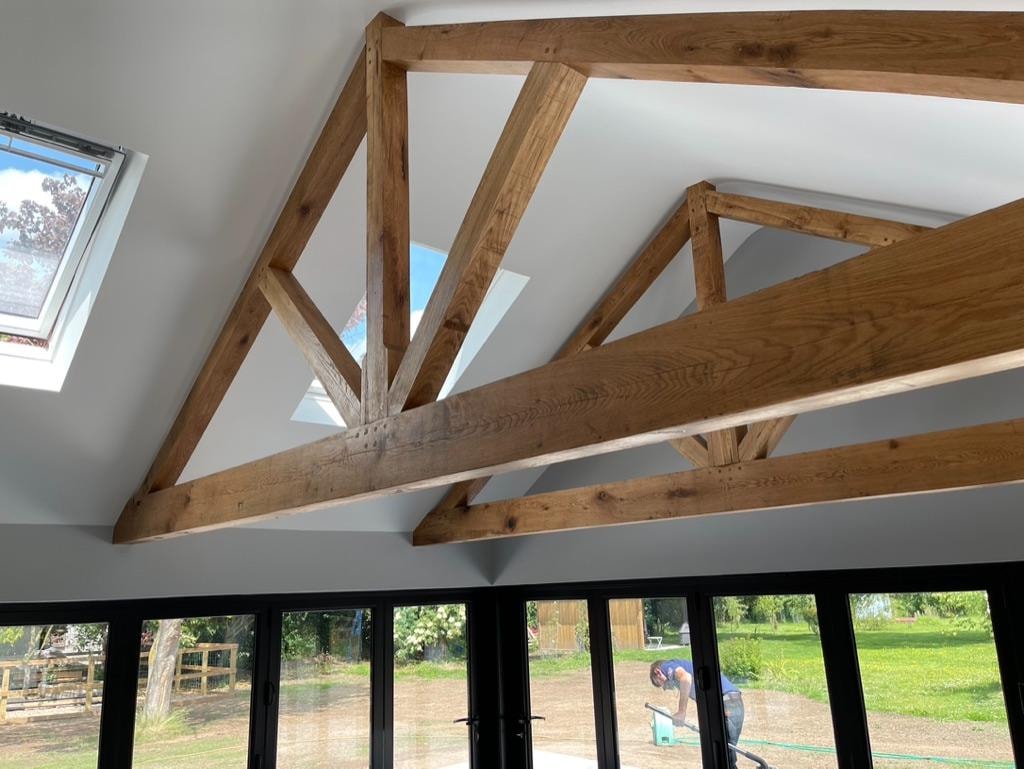 Barn-style new build — interior with exposed oak trusses and bifold doors