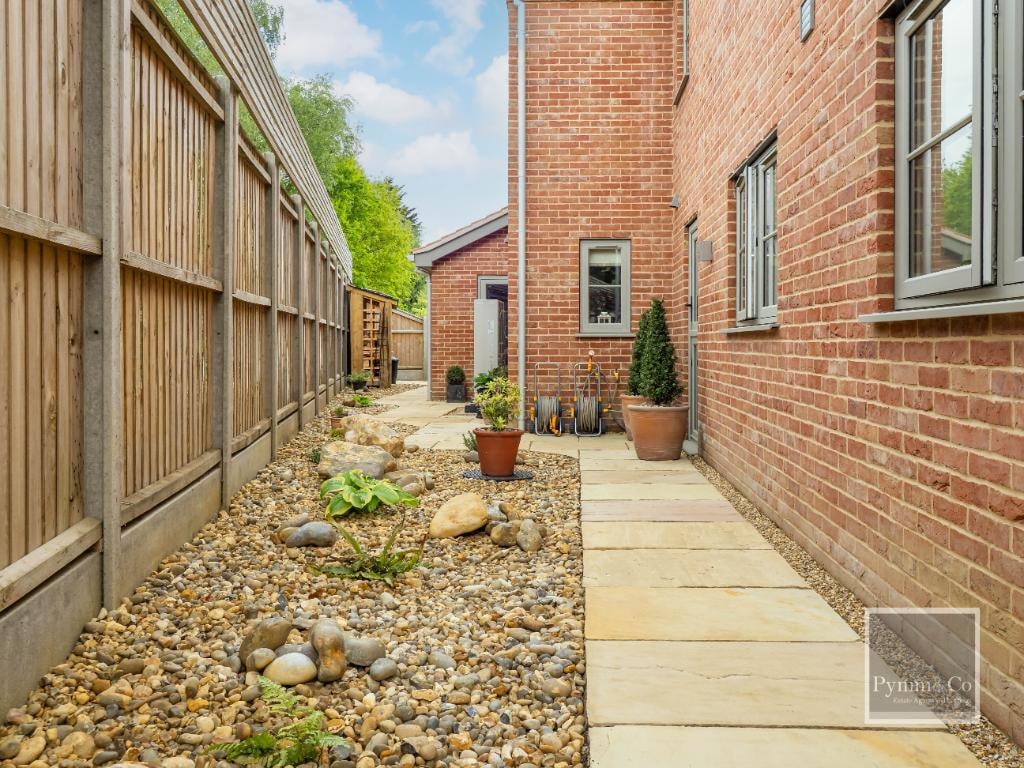 Landscaping — sandstone path with gravel planting bed, timber fencing and brick courtyard