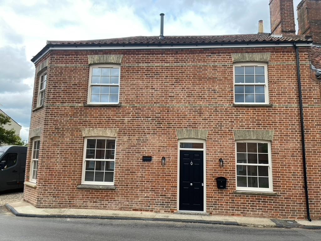 Malthouse refurbishment — brick façade with sash windows and black front door